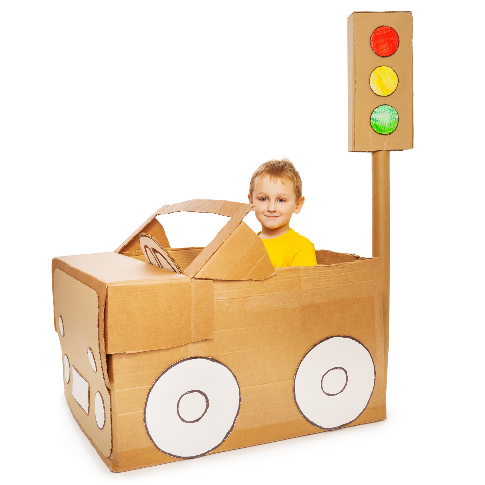 Little boy driving his handmade cardboard car, isolated on white background